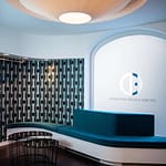 repräsentativer Empfangsbereich und Warte-Bereich mit geschwungenen Wänden und organisch geformten petrol-farbem Sitzmöbel und passender Ornament-Tapete Praxis-Design in der Praxis für Ästhetische Medizin Dr. med. Eveline Urselmann Milchstrasse 26 bis 28 Hamburg Pöseldorf Rotherbaum im ästhetischen und zeitlosen Design von Lange Architekten