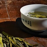 Tea_Passion_Sven-Christian Lange_Branding Photography_Tea Tasting With Green Tea Tai Ping Hou Kui With White Bowl With Blue Characters On Antique Korean Wooden Plate_Tea Ceremony