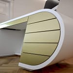 repräsentatives weißes Behandlungszimmer und Besprechungszimmer mit individuellem Produkt-Design Schreibtisch mit Formholz und goldfarbenen Akzenten Praxis-Design in der Praxis Frauenaerztin am Rothenbaum Dipl. med. Tatjana Swirski Curiohaus Rothenbaumchaussee Hamburg Harvestehude im ästhetischen und zeitlosen Design von Lange Architekten
