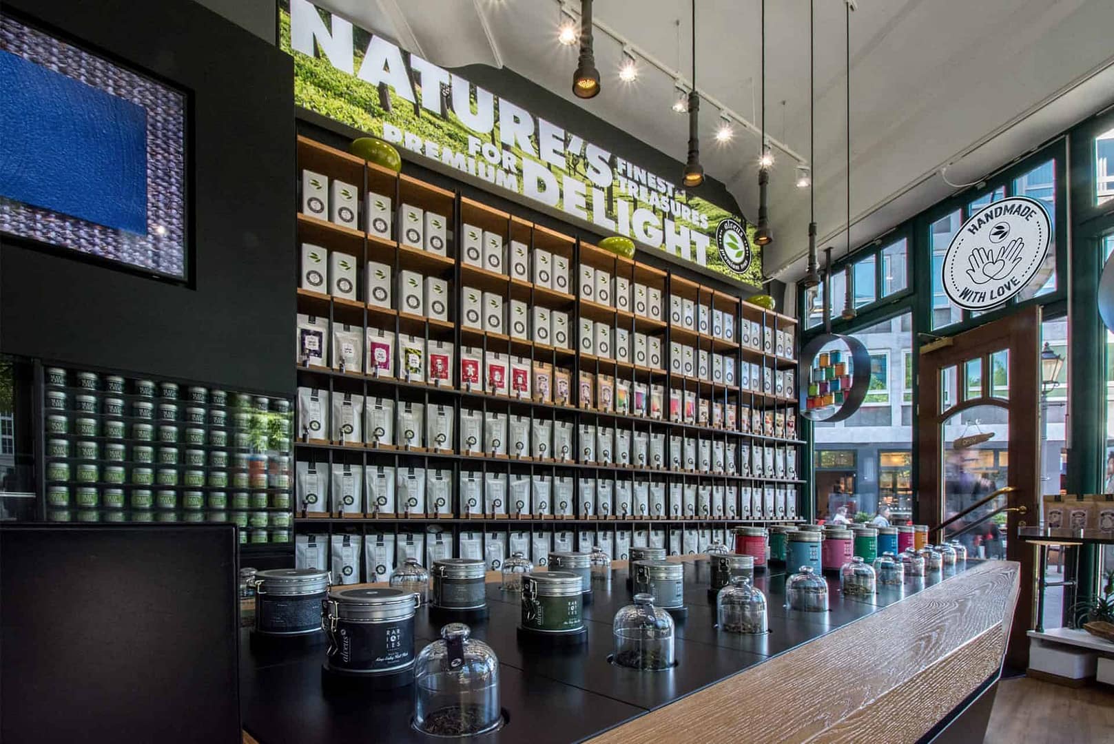 perfektes und funktionales Tee Store Konzept Retail-Design Produkt-Design Corporate-Design von Lange Architekten im ersten alveus Bio-Tee Tea-Store Alster mit Akzenten in Eichenholz und Stahl mit Probier-Tresen und Tee-Regalen mit Tester-Gläsern in den Colonnaden Hamburg