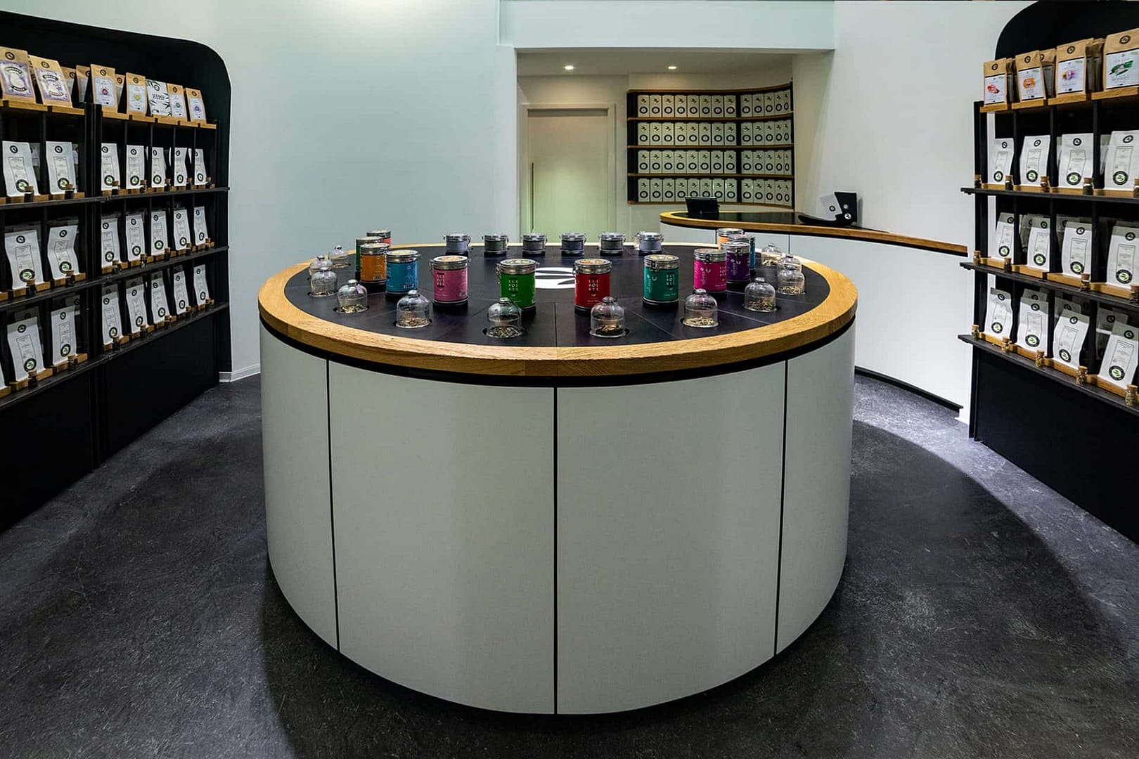 perfektes organisches und funktionales Tee Store Konzept Retail-Design Produkt-Design Corporate-Design von Lange Architekten im weißen alveus Bio-Tee Tea-Store mit Akzenten in Eichenholz und Stahl mit Probier-Tresen und Tee-Regalen in der HafenCity Hamburg unweit der Elbphilharmonie