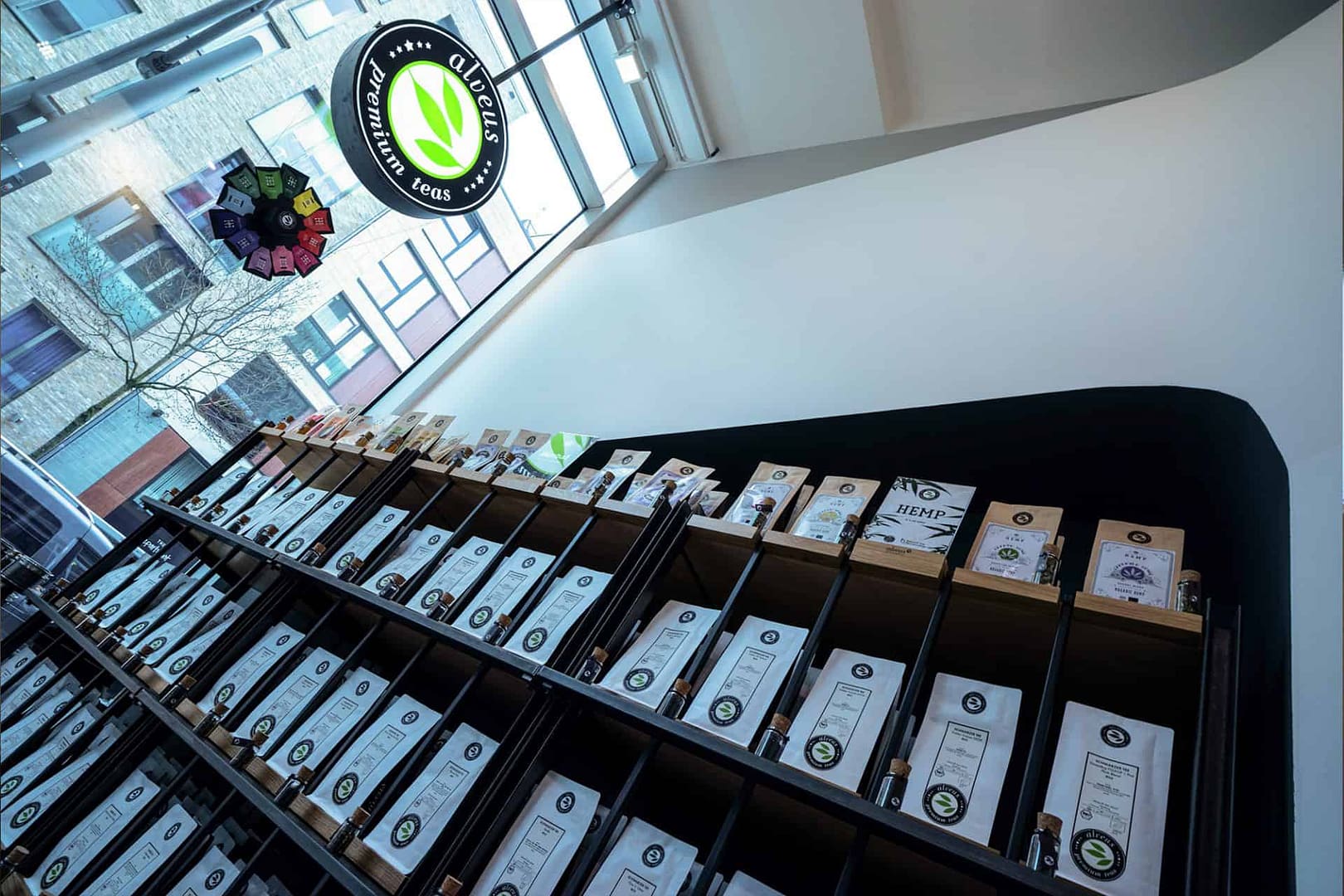 perfektes organisches und funktionales Tee Store Konzept Retail-Design Produkt-Design Corporate-Design von Lange Architekten im weißen alveus Bio-Tee Tea-Store mit Akzenten in Eichenholz und Stahl und Tea-Store-Shelf Tee-Regal Serienprodukt in der HafenCity Hamburg unweit der Elbphilharmonie