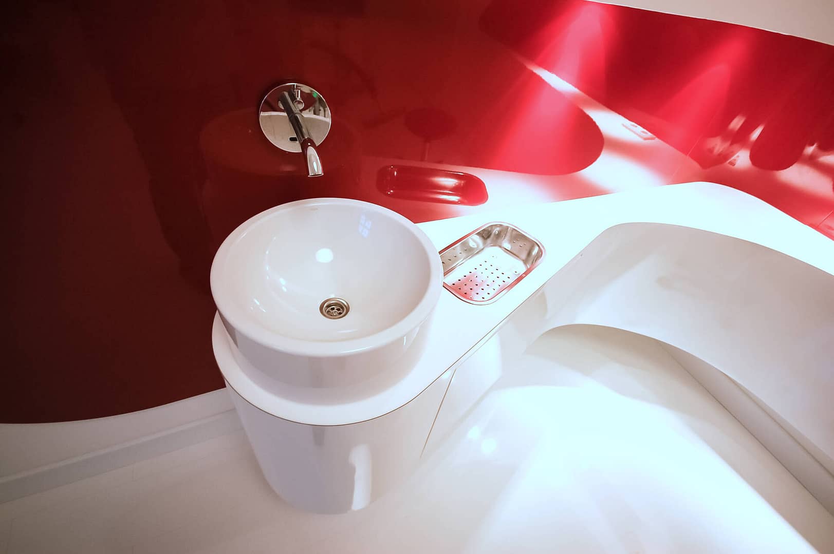 weißes Behandlungszimmer mit Formholz-Elementen Corian und Akzenten in Hochglanz-Rot organisches Funktionsmöbel mit Waschbecken Praxis-Design in der Praxis Frauenaerztin am Rothenbaum Dipl. med. Tatjana Swirski Curiohaus Rothenbaumchaussee Hamburg Harvestehude im ästhetischen und zeitlosen Design von Lange Architekten